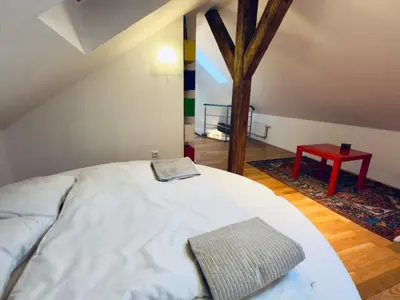 a bedroom with a bed and a red table at Attic 15 min to Charles Bridge in Prague