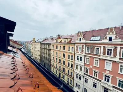 a view of the roofs of buildings in a city at Attic 15 min to Charles Bridge in Prague