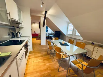 a kitchen and dining room with a table and chairs at Attic 15 min to Charles Bridge in Prague