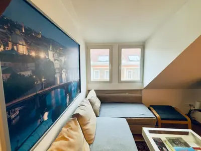 a living room with a large painting on the wall at Attic 15 min to Charles Bridge in Prague