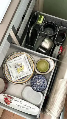 a drawer filled with plates and bowls on a shelf at Riverside serenity Modern apartment with sunset views in Prague