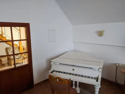 a white piano sitting in a room next to a door at Wellness resort Kytra in Slavětín