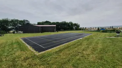 a tennis court in the middle of a field at Wellness resort Kytra in Slavětín