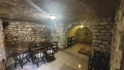 a room with a table and chairs and a stone wall at Wellness resort Kytra in Slavětín