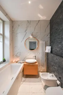 a bathroom with a tub and a sink and a mirror at Elegant Garden Apartment near Main Station in Prague