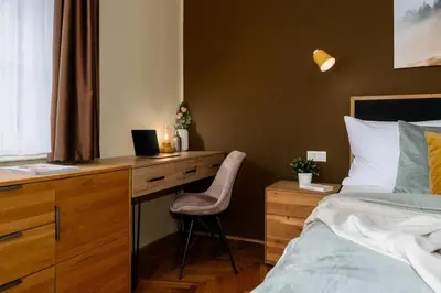 a bedroom with a bed and a desk with a computer at Spacious 2BR Vršovice | AC • Netflix • Cozy Stay in Prague