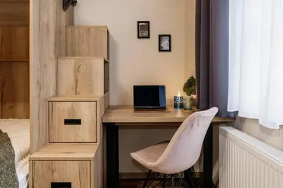 a bedroom with a desk with a laptop and a chair at Spacious 2BR Vršovice | AC • Netflix • Cozy Stay in Prague