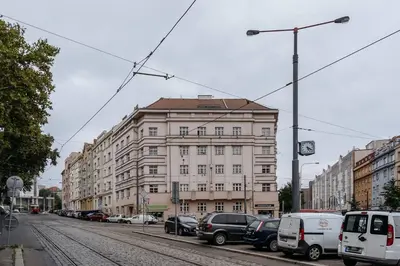 a large building on a city street with parked cars at Spacious 2BR Vršovice | AC • Netflix • Cozy Stay in Prague