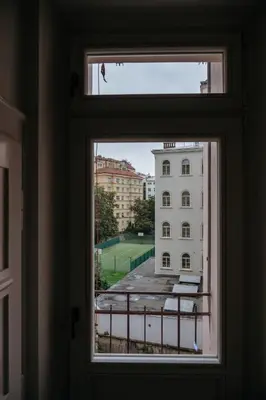 a window with a view of a building at Spacious 2BR Vršovice | AC • Netflix • Cozy Stay in Prague