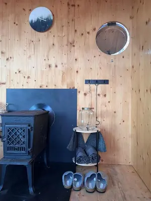 a room with a stove and a table with shoes at Tinyhouse Veranda