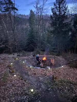 a man sitting around a table with a fire at Tinyhouse Veranda
