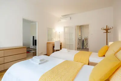 a bedroom with two beds with yellow and white at Hubert Family Rezidence Prague in Prague