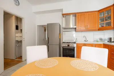a kitchen with a table and two white chairs at Hubert Family Rezidence Prague in Prague