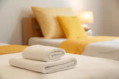 a stack of towels on a bed in a hotel room at Hubert Family Rezidence Prague in Prague