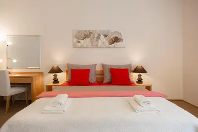 a bedroom with a large bed with red pillows at Hubert Family Rezidence Prague in Prague
