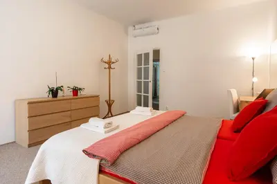a bedroom with a red bed and a dresser at Hubert Family Rezidence Prague in Prague