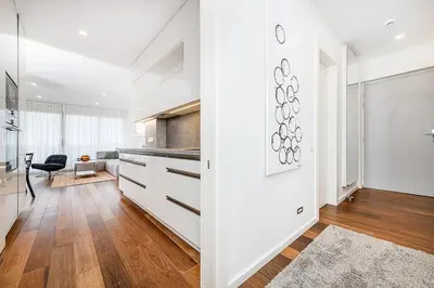 a kitchen with white cabinets and a table at Stunning Modern 2bedroom with Iconic View in Prague
