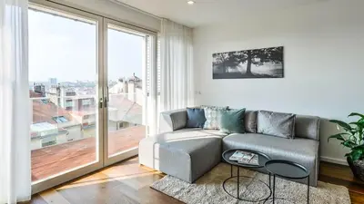 a living room with a couch and a large window at Stunning Modern 2bedroom with Iconic View in Prague