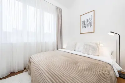 a white bedroom with a bed and a window at Stunning Modern 2bedroom with Iconic View in Prague