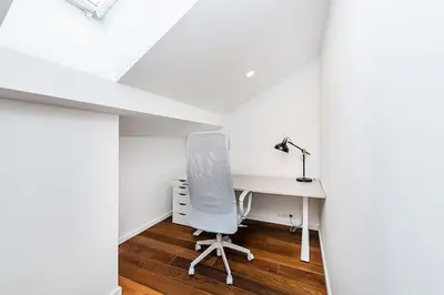 a white desk and a chair in a room at Stunning Modern 2bedroom with Iconic View in Prague
