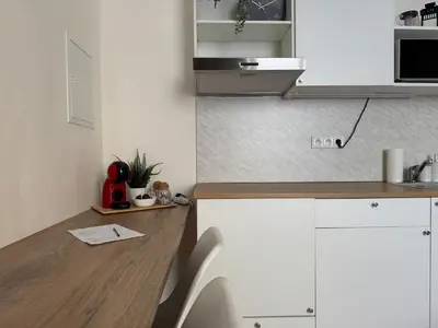 a kitchen with white cabinets and a wooden counter top at Alabaster - Prague Apartment in Prague