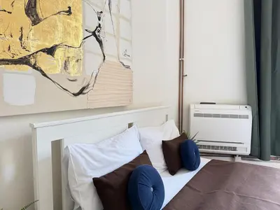 a bedroom with a bed with blue pillows at Alabaster - Prague Apartment in Prague