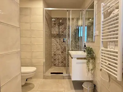 a bathroom with a shower and a toilet and a sink at Alabaster - Prague Apartment in Prague