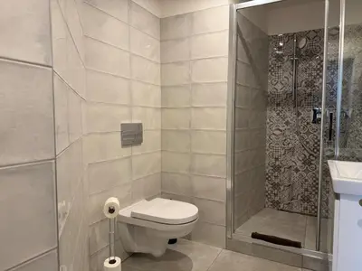 a small bathroom with a toilet and a shower at Alabaster - Prague Apartment in Prague