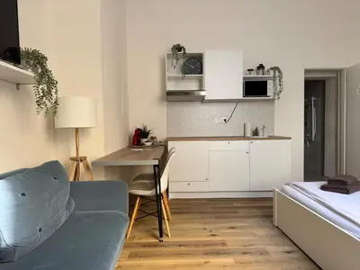 a kitchen with a couch and a table in a room at Alabaster - Prague Apartment in Prague