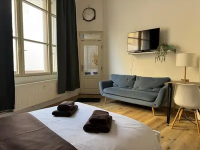 a living room with a bed and a couch at Alabaster - Prague Apartment in Prague