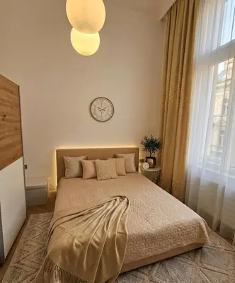 a bedroom with a bed with a clock on the wall at Beautiful apartment with terrace in center of Prague in Prague