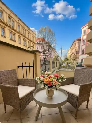 a table with a vase of flowers on a patio at Beautiful apartment with terrace in center of Prague in Prague