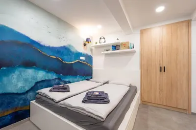 a room with a bed with a painting on the wall at Secret Garden Studio in Prague