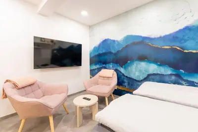 a bedroom with two chairs and a painting on the wall at Secret Garden Studio in Prague