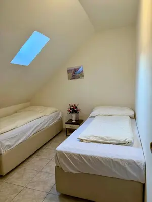 two beds in a small room with a window at Ubytovna u Maiky in Libochovice