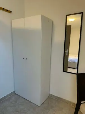 a white cabinet in a room with a mirror at Ubytovna u Maiky in Libochovice