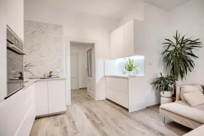 a white kitchen with white cabinets and a couch at 100m2, 3 room, Old Town Prague Flat in Golčŭv Jeníkov