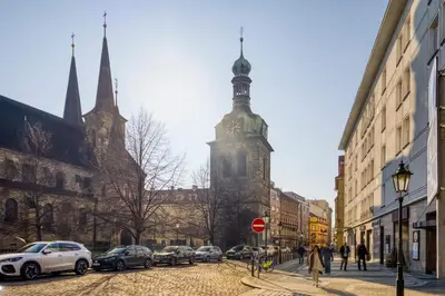 a building with a tower with cars parked on a street at 100m2, 3 room, Old Town Prague Flat in Golčŭv Jeníkov