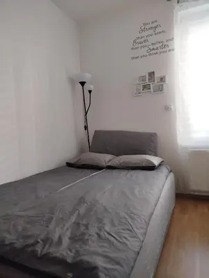 a bed in a room with a lamp on the wall at Spacious apartment with garden and private parking in Prague