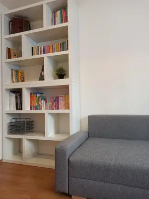 a living room with a couch and book shelves at Spacious apartment with garden and private parking in Prague