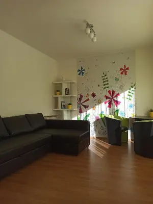 a living room with a black couch and a table at Spacious apartment with garden and private parking in Prague