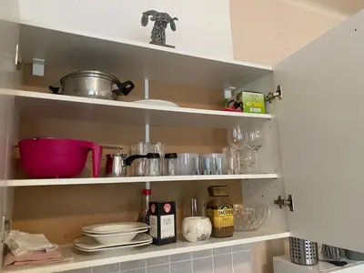 a kitchen shelf with dishes and other kitchen items at Prague Old Town Apartment Benediktska 6 in Prague