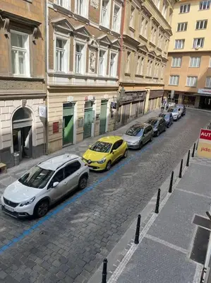 a row of cars parked on a street next to a building at Prague Old Town Apartment Benediktska 6 in Prague