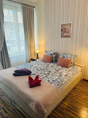 a bedroom with a large bed with a red bow on it at Prague Old Town Apartment Benediktska 6 in Prague