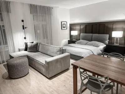 a living room with a couch and a bed and a table at Design apartment in Prague 6 in Prague