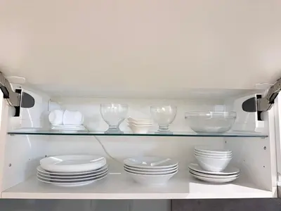 a cabinet filled with white dishes and bowls and plates at Apartment MozArt Prague in Prague