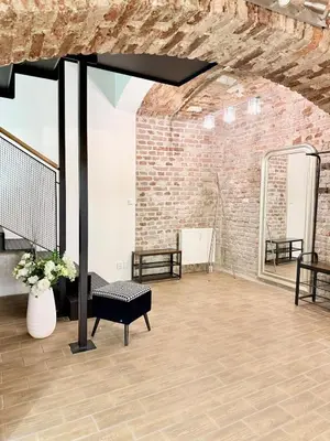 a room with a brick wall and a table and a bench at Apartment MozArt Prague in Prague