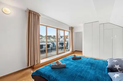 a bedroom with a blue bed and a large window at Nature Diamond Suite in Prague