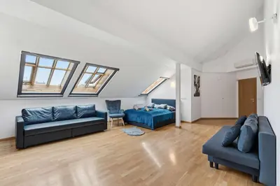 a living room with two blue couches and a tv at Nature Diamond Suite in Prague