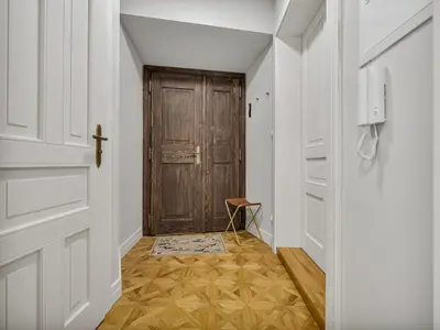 a hallway with a wooden door and a wooden floor at Romantic Apartman by Prague Castle in Prague